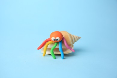 Crab made from plasticine on light blue background. Children's handmade ideas