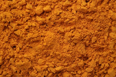 Aromatic turmeric powder as background, top view
