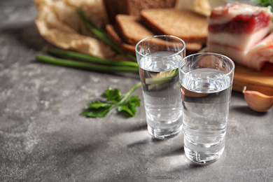 Photo of Cold Russian vodka with snacks on grey table