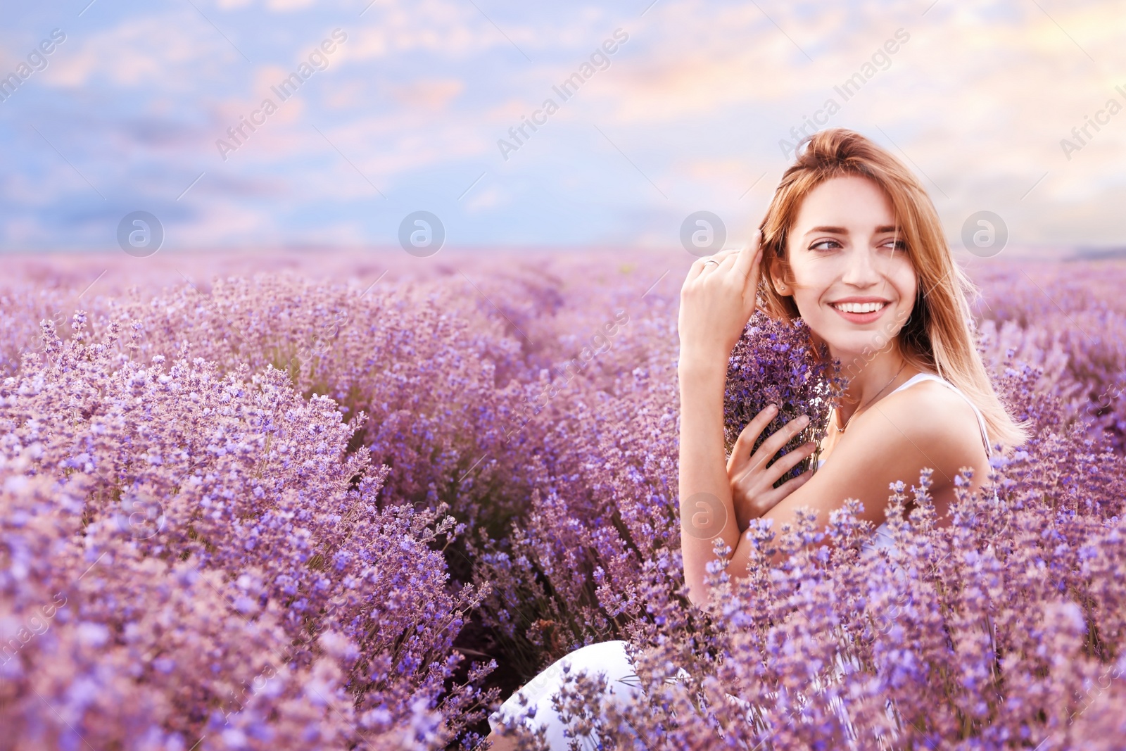 Photo of Young woman with bouquet in lavender field