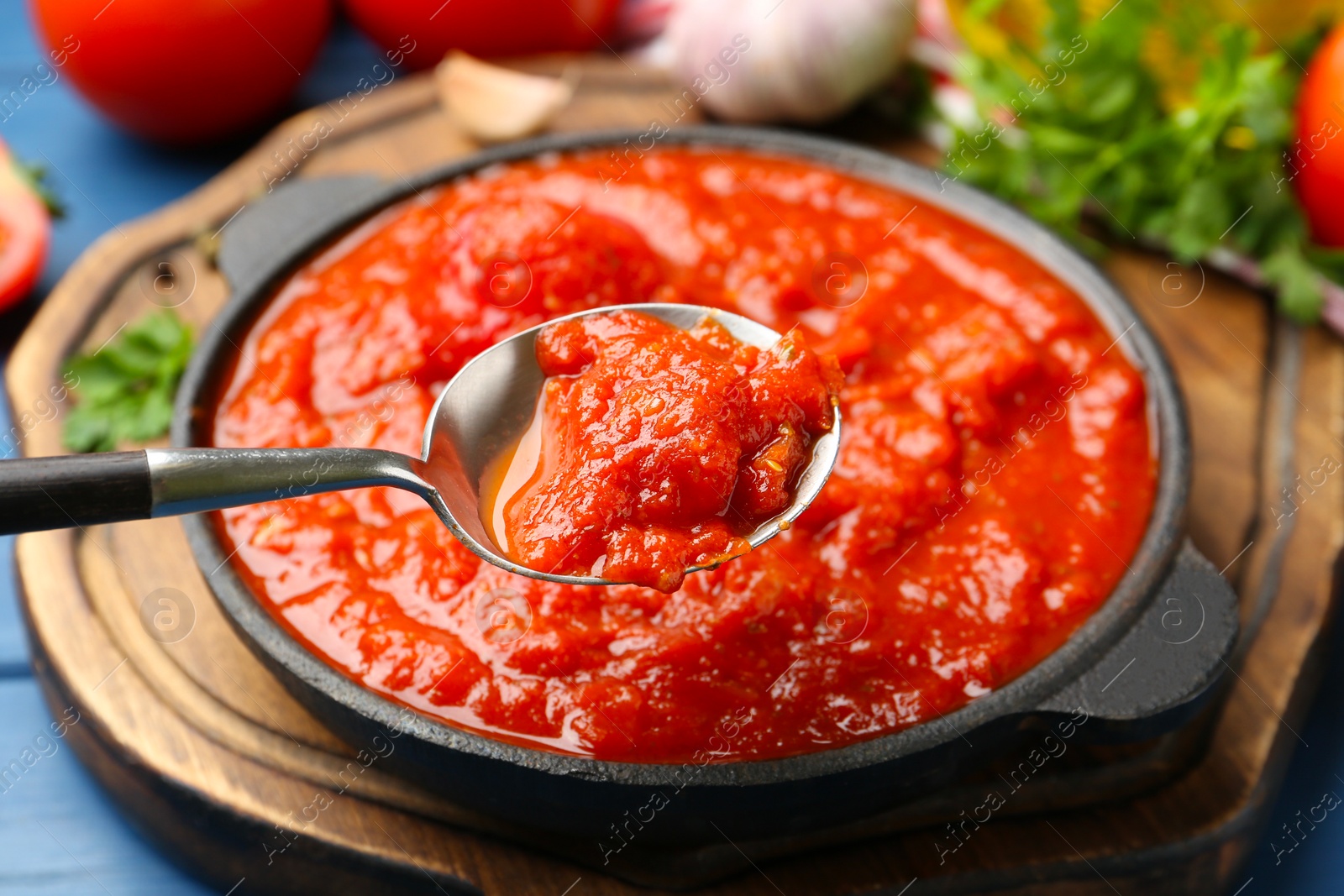 Photo of Eating homemade tomato sauce at blue table, closeup