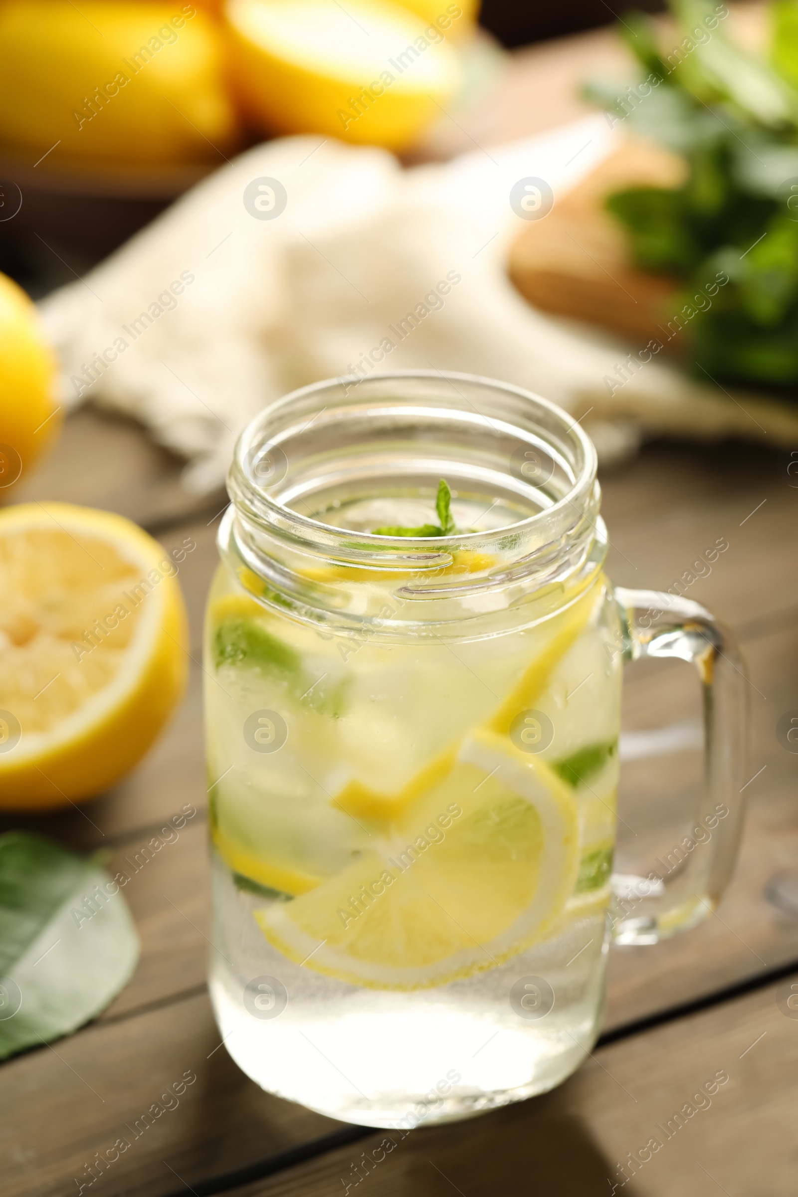 Photo of Mason jar of cold lemonade on wooden table