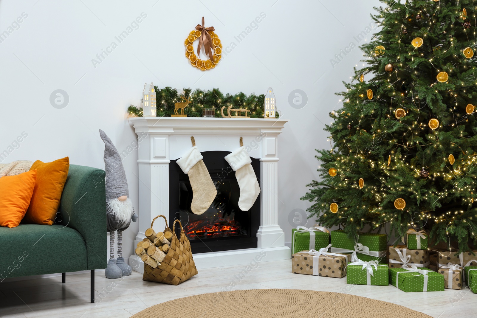 Photo of Cozy living room with fireplace and gifts under Christmas tree. Interior design