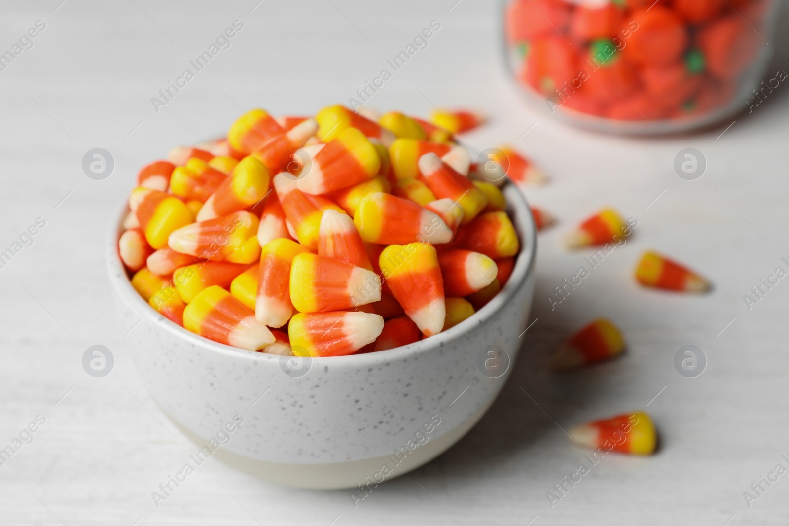 Photo of Bowl with tasty candy corns on table, closeup