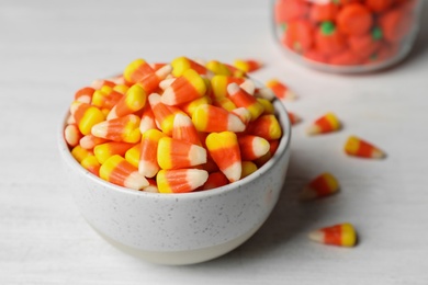 Bowl with tasty candy corns on table, closeup