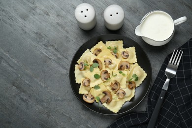 Delicious ravioli with mushrooms served on grey table, flat lay. Space for text