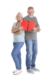 Photo of Mature couple with torn paper heart on white background. Relationship problems
