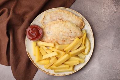 Delicious fish and chips with ketchup on brown table, top view