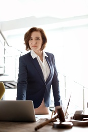 Female lawyer standing near table in office