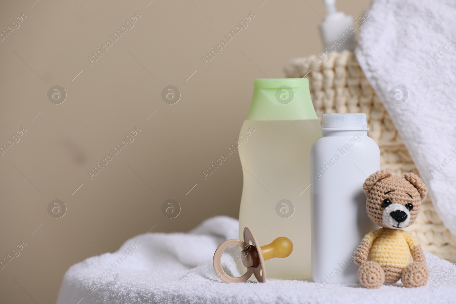 Photo of Baby cosmetic products, toy bear and pacifier on beige background. Space for text