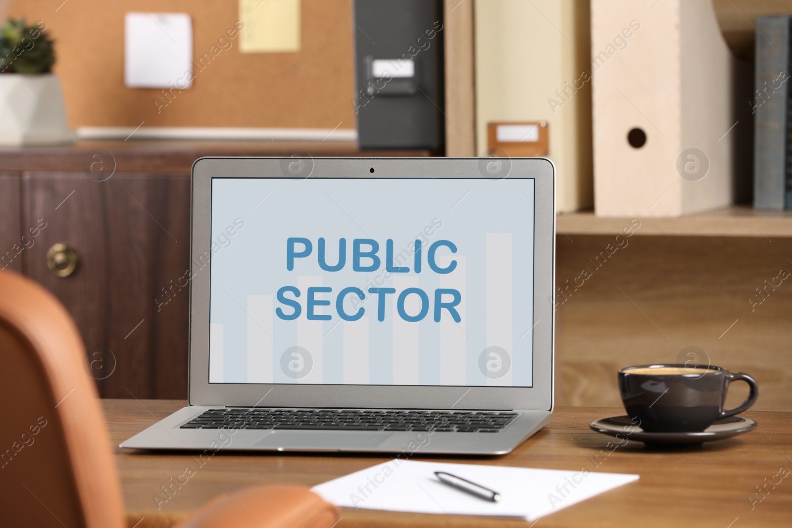 Image of Public Sector. Modern laptop and cup on table in office