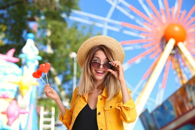 Beautiful woman with candies having fun at amusement park