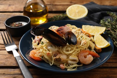 Photo of Delicious pasta with sea food served on wooden table