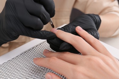 Photo of Professional manicurist working with client, closeup view