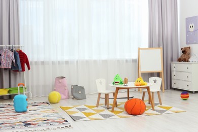 Photo of Child`s playroom with different toys and modern furniture. Stylish kindergarten interior