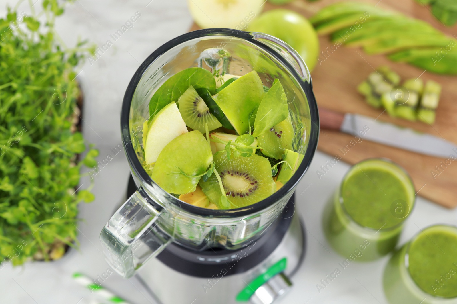 Photo of Blender with ingredients for smoothie on white table, above view