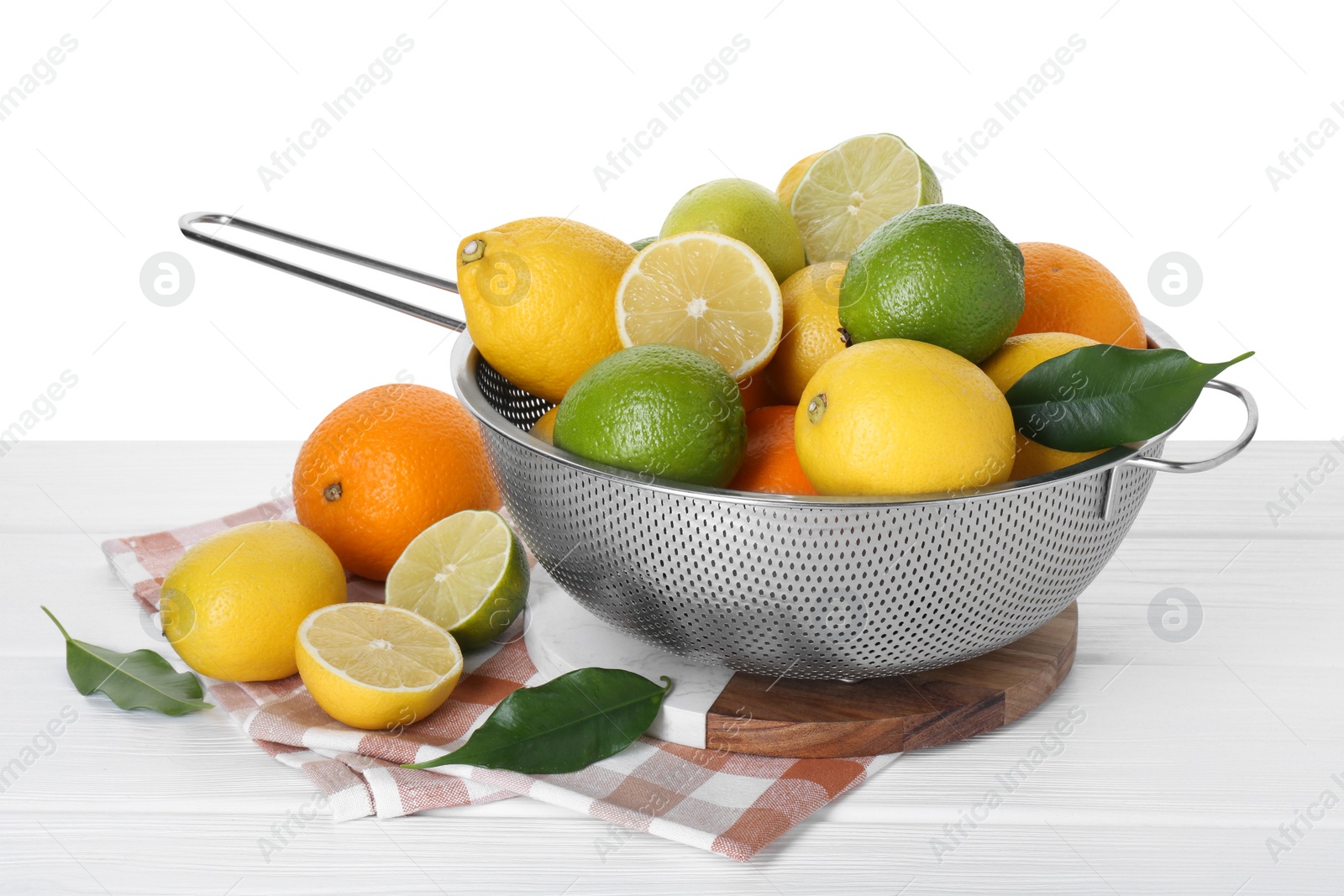 Photo of Metal colander with citrus fruits on table against white background