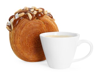 Photo of Round croissant with chocolate paste, nuts and cup of drink isolated on white. Tasty puff pastry