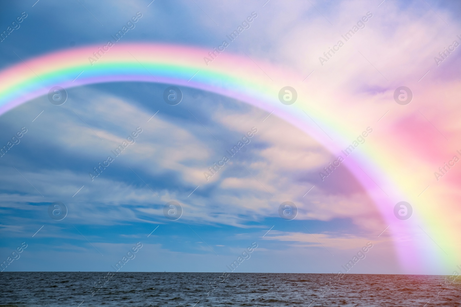 Image of Beautiful view of colorful rainbow in sky over sea