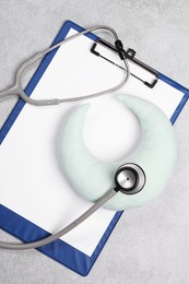 Clipboard, stethoscope and pillow on gray background, top view