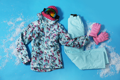 Photo of Stylish winter sport clothes on light blue background, flat lay