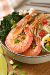 Photo of Delicious ramen with shrimps and egg in bowl on table, closeup. Noodle soup