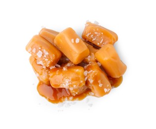 Photo of Yummy caramel candies and sea salt isolated on white, top view