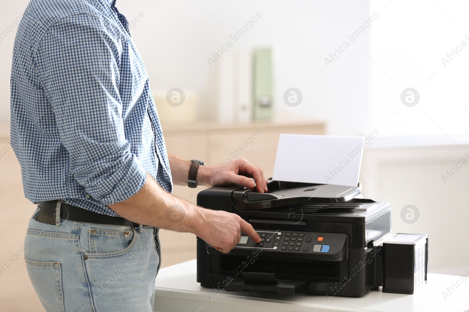 Photo of Employee using modern printer in office, closeup