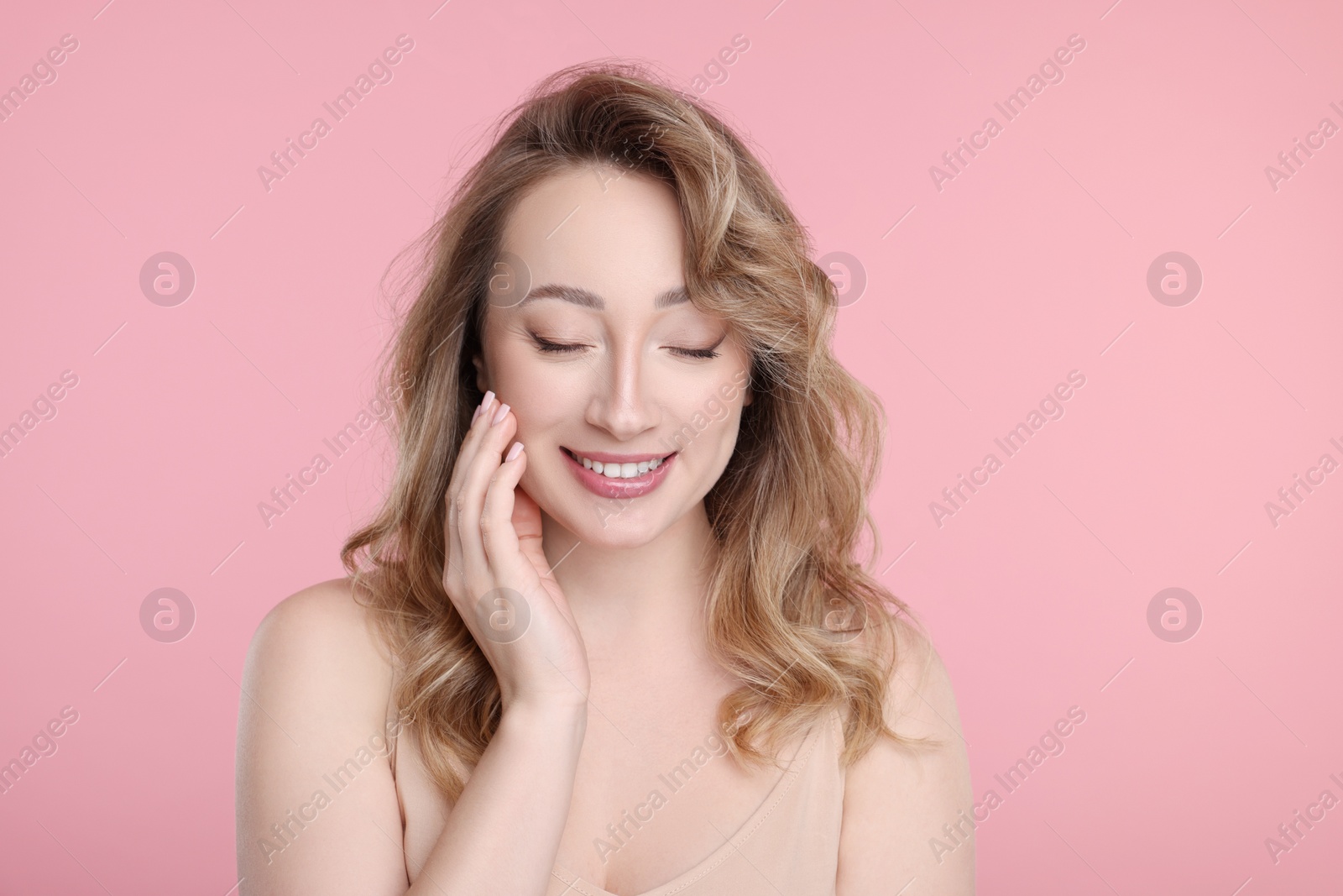 Photo of Portrait of smiling woman on pink background