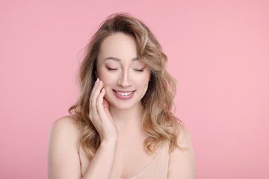 Portrait of smiling woman on pink background