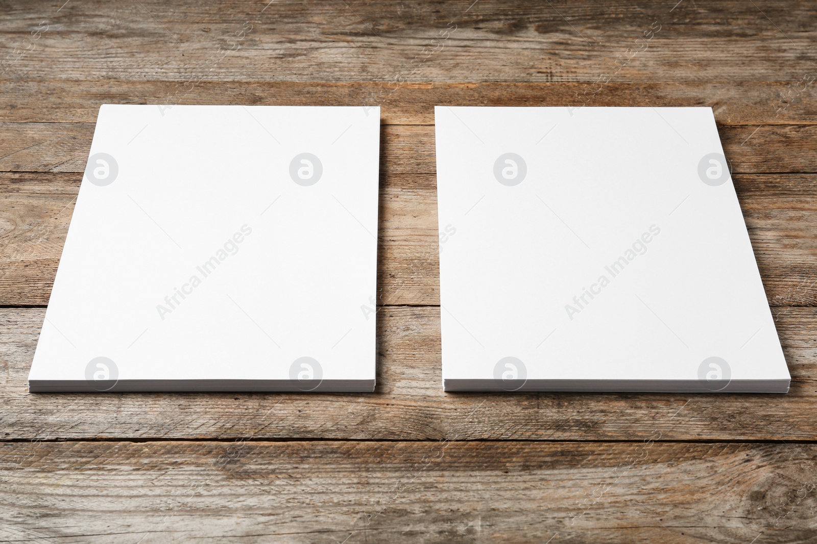 Photo of Blank paper sheets for brochure on wooden background. Mock up