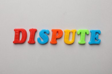 Photo of Word Dispute made of colorful letters on light grey background, flat lay