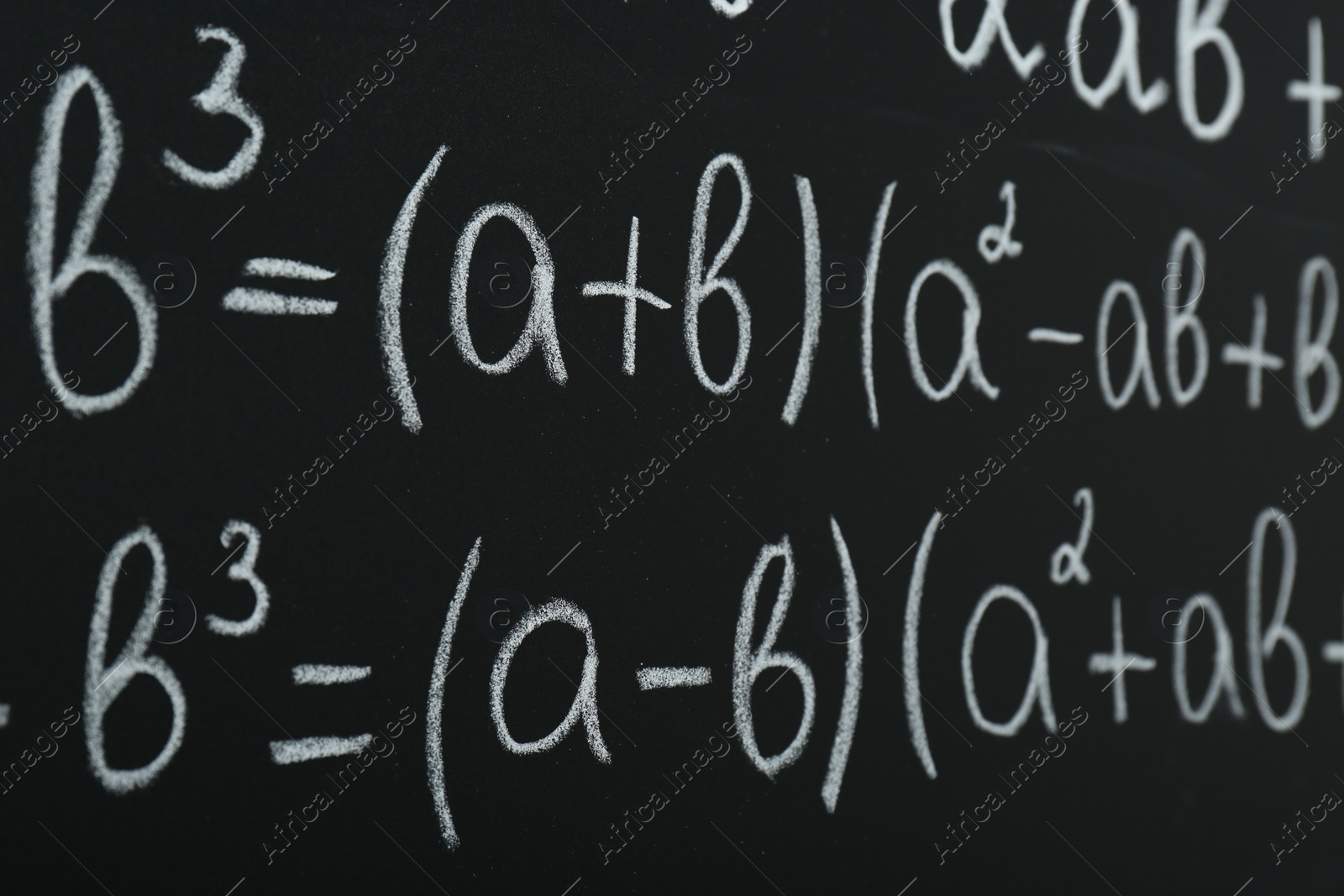 Photo of Many different math formulas written on chalkboard, closeup