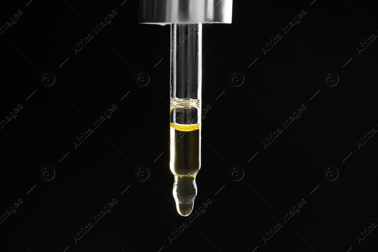 Photo of Pipette with tincture on black background, closeup