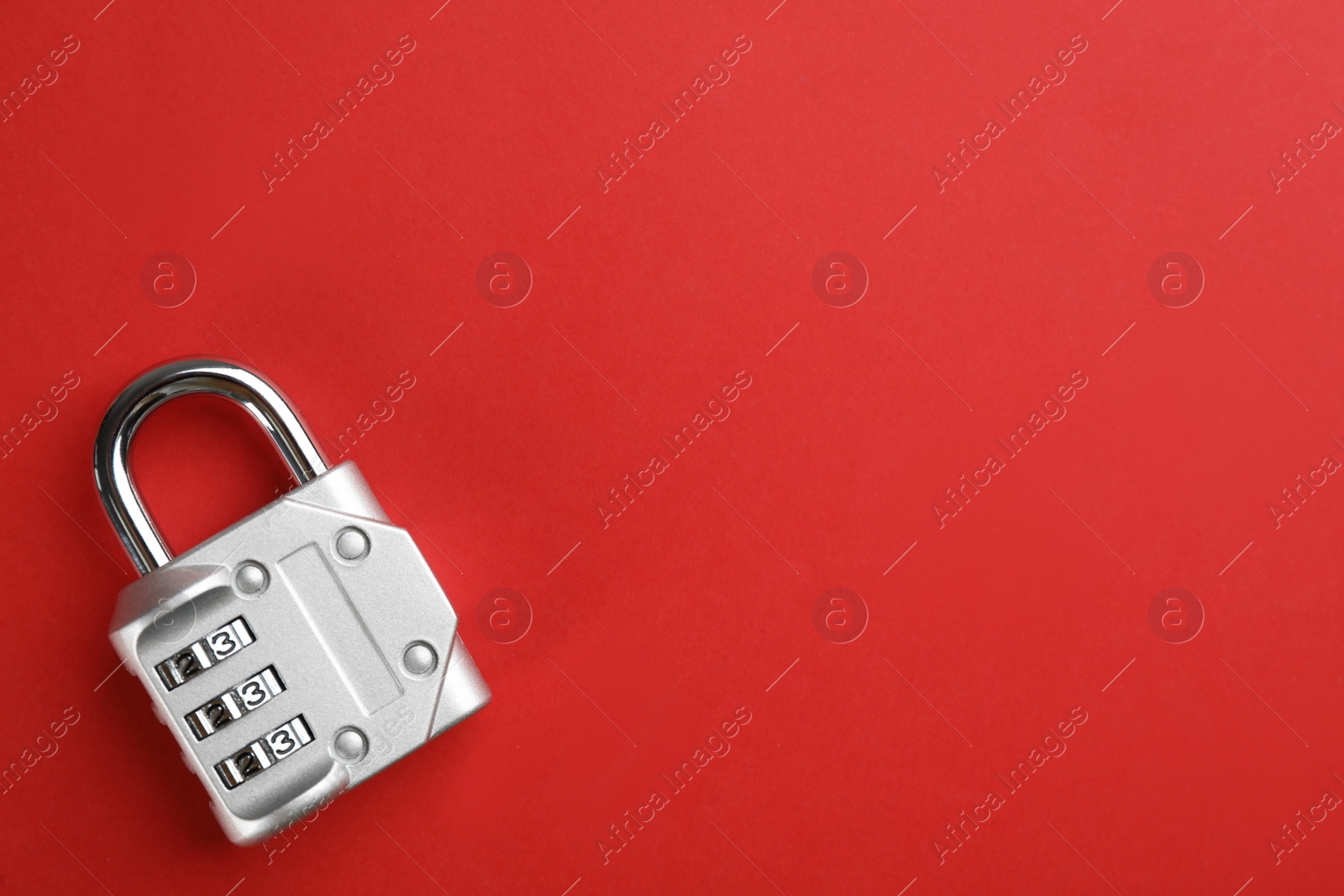 Photo of Modern combination lock on red background, top view. Space for text