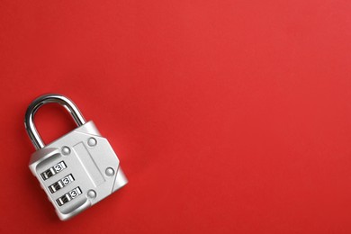 Photo of Modern combination lock on red background, top view. Space for text