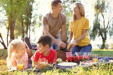 Happy family having picnic in park on sunny day