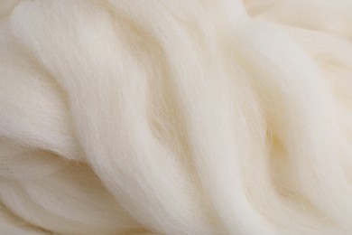 Photo of White felting wool as background, closeup view