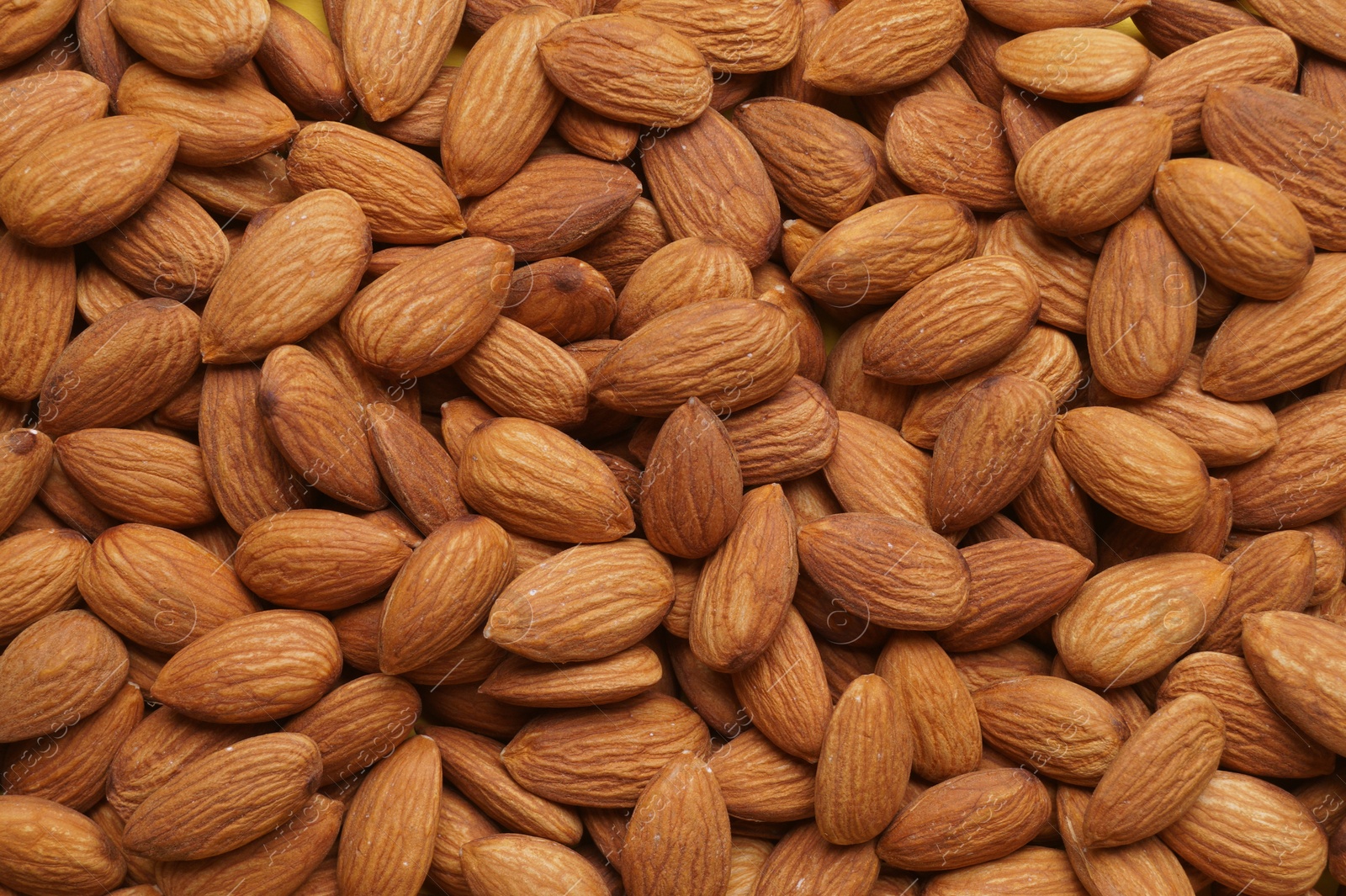 Photo of Delicious raw ripe almonds as background, top view