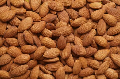 Delicious raw ripe almonds as background, top view