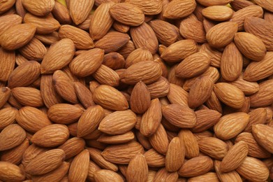 Photo of Delicious raw ripe almonds as background, top view