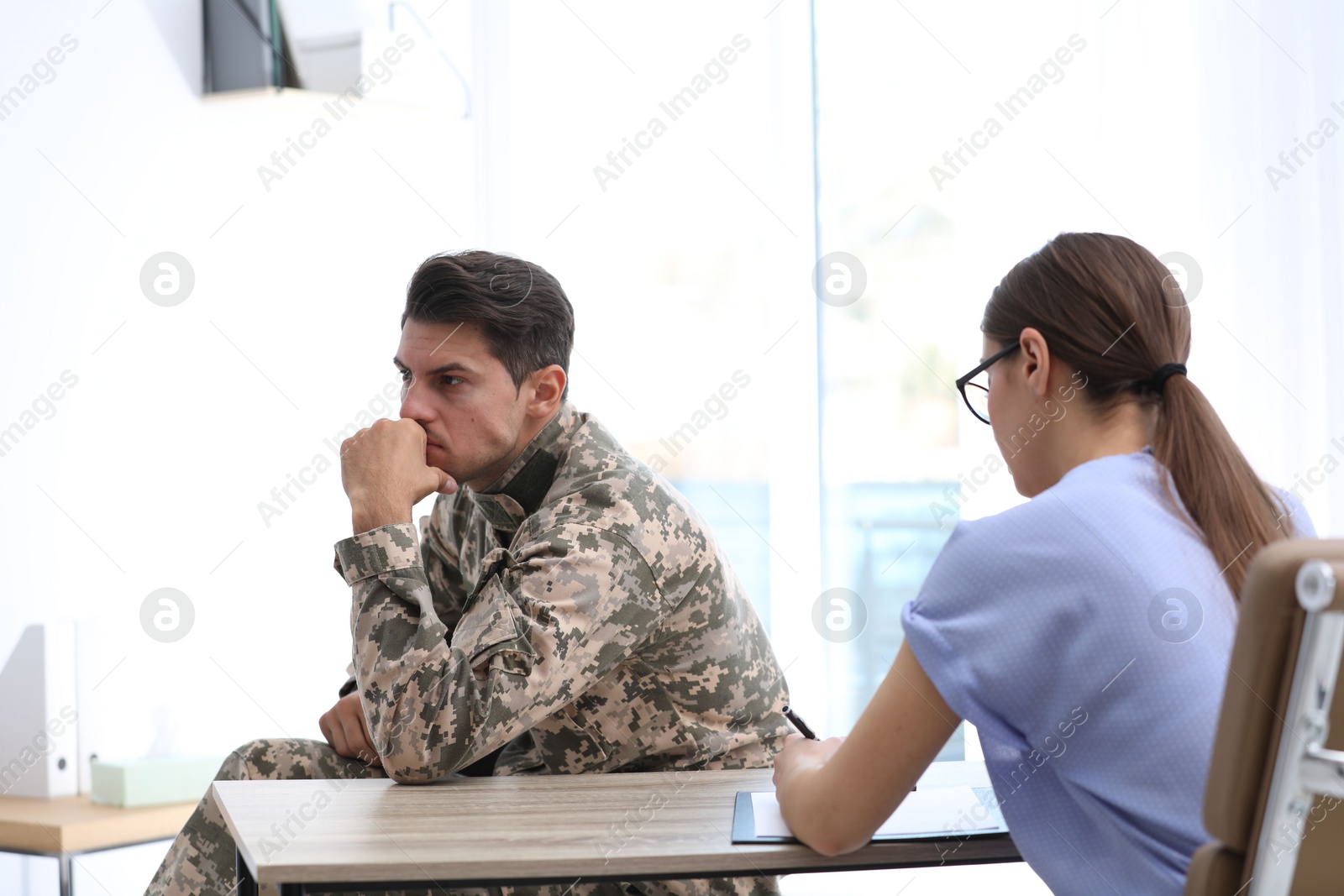 Photo of Psychotherapist working with male military officer in office