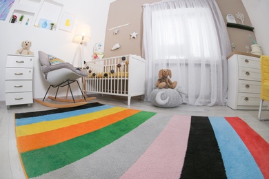 Photo of Cozy baby room interior with crib and rocking chair