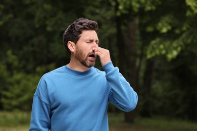 Photo of Man suffering from seasonal spring allergy outdoors