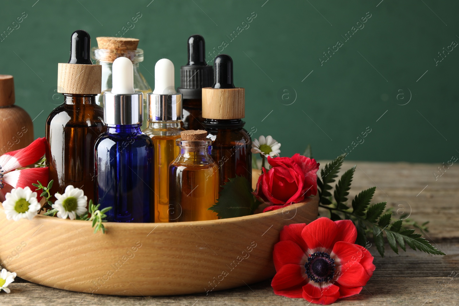 Photo of Aromatherapy. Different essential oils and flowers on wooden table