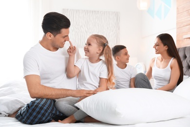 Photo of Happy young family together on large bed