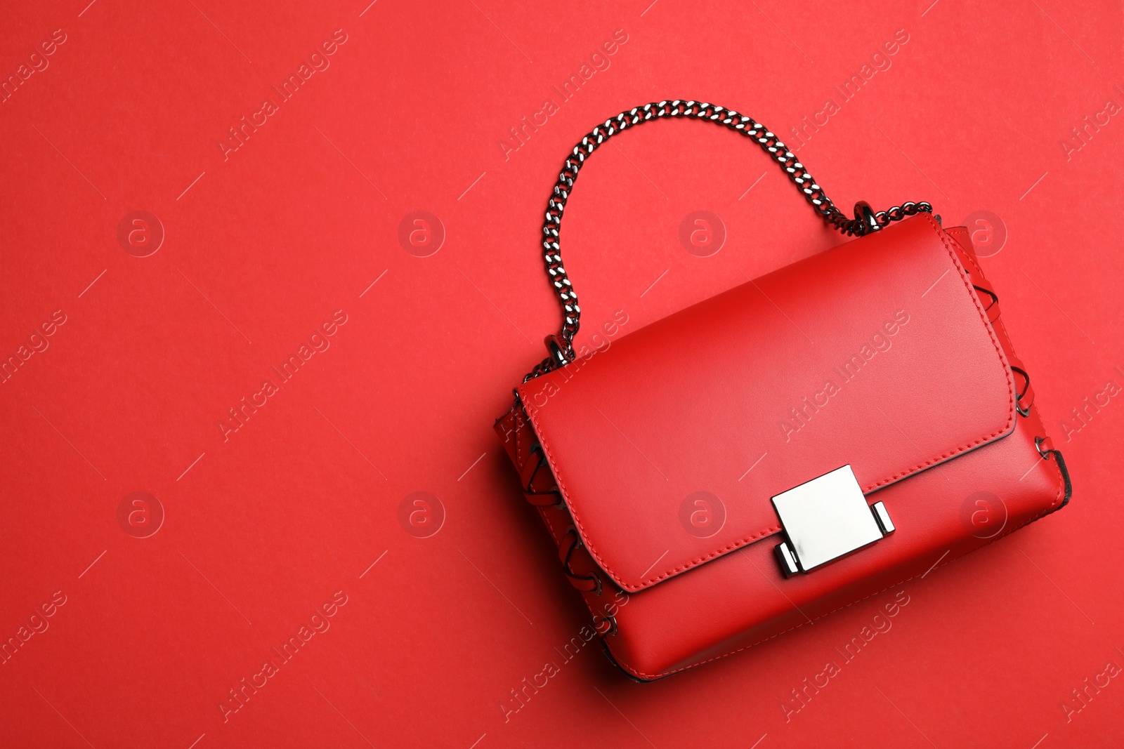 Photo of Stylish woman's bag on red background, top view. Space for text