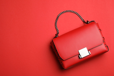 Photo of Stylish woman's bag on red background, top view. Space for text