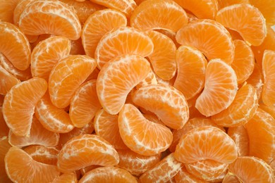 Photo of Delicious tangerine segments as background, top view
