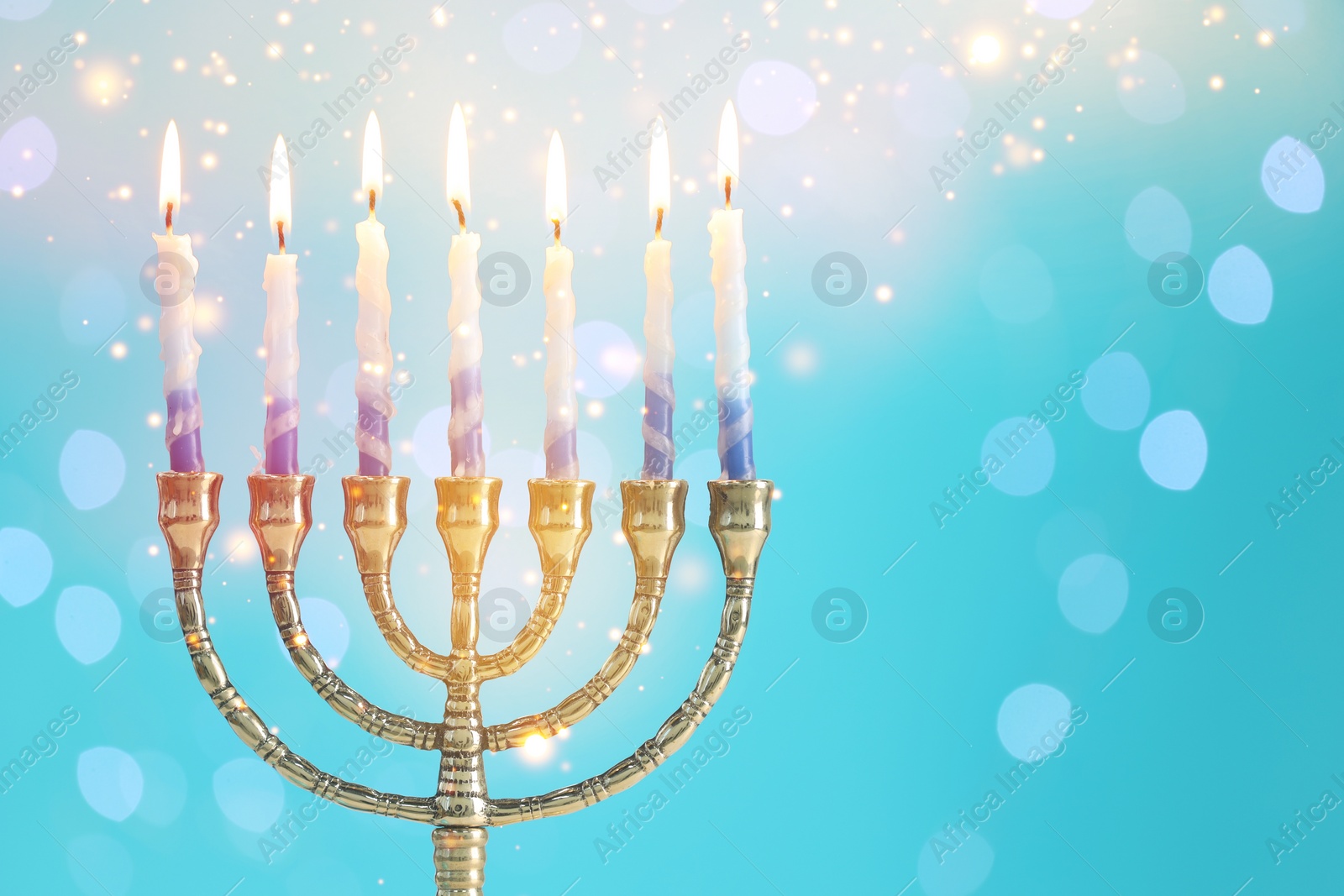 Image of Hanukkah celebration. Menorah with burning candles on light blue background with blurred lights, space for text